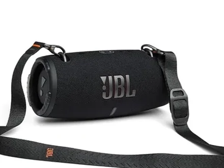 A black portable speaker with its shoulder strap, on white