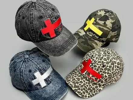 Five washed denim and camouflage caps with cross and X logos on grey