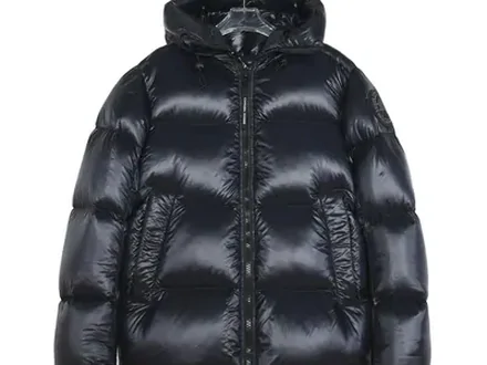 A single black puffer jacket photographed alone against a pale grey background